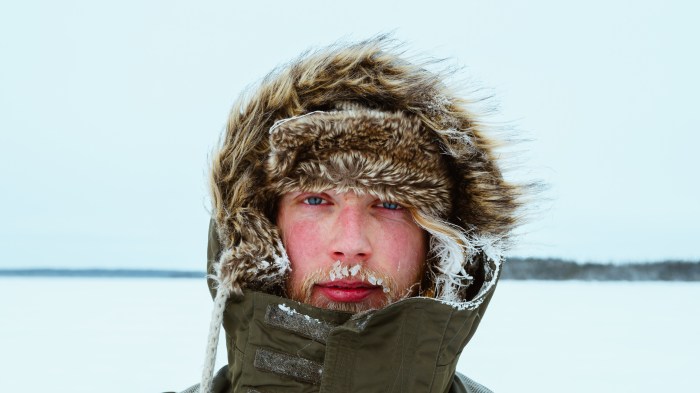 Un hombre cubre su cabeza en medio de un paisaje frío.