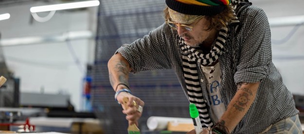 La imagen muestra al actor Johnny Depp pintando un cuadro.