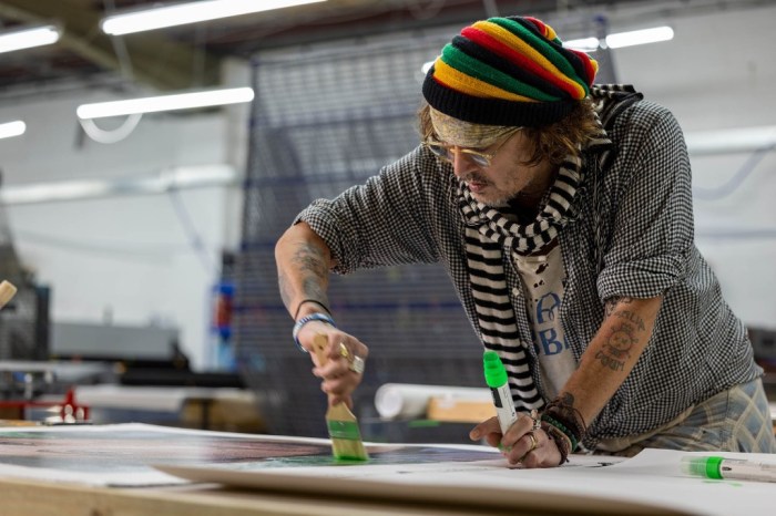 La imagen muestra al actor Johnny Depp pintando un cuadro.