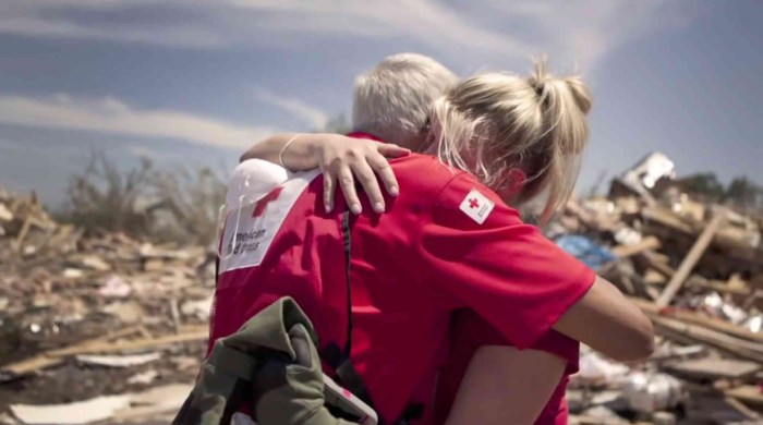 La imagen muestra a un voluntario de Cruz Roja abrazando a una mujer.