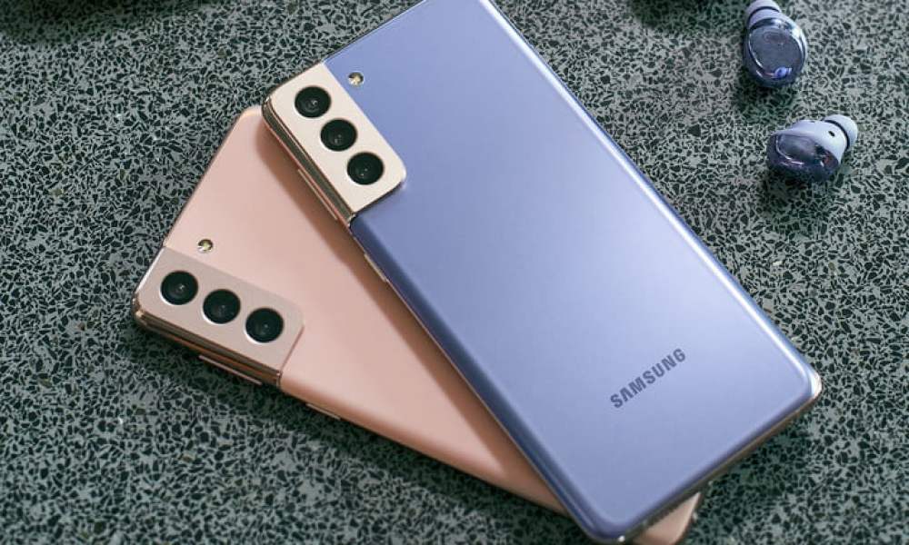 Dos Samsung Galaxy s21 en color rosa y azul, uno sobre otro en una superficie gris.