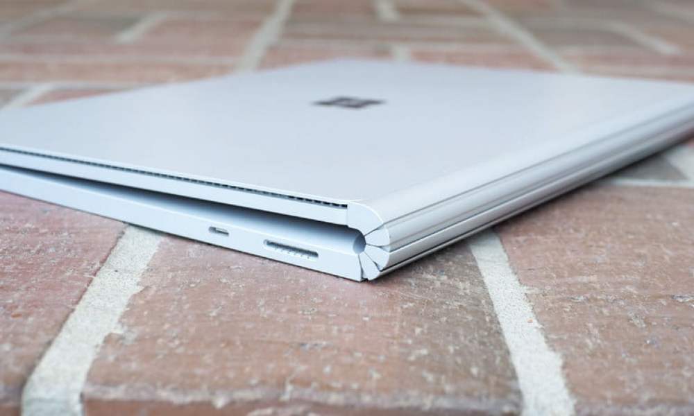 Surface Book 3 blanca sobre una superficie de ladrillo rojo que muestra la bisagra del punto de apoyo.