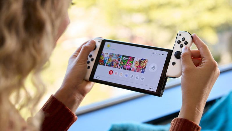 Una persona utiliza una consola Nintendo Switch OLED.