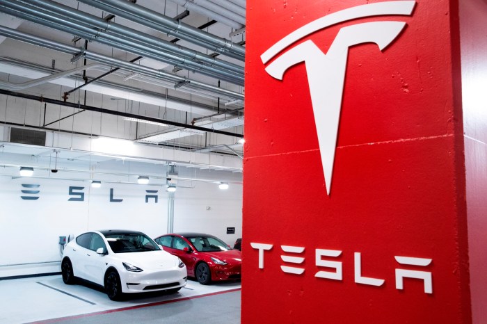 Dos vehículos de Tesla junto al logo de la compañía.