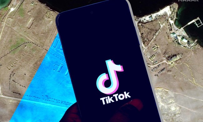 Un celular con el logo de la aplicación TikTok. En el fondo, una vista aérea del área de Novoozerne y el Lago Donuzlav.