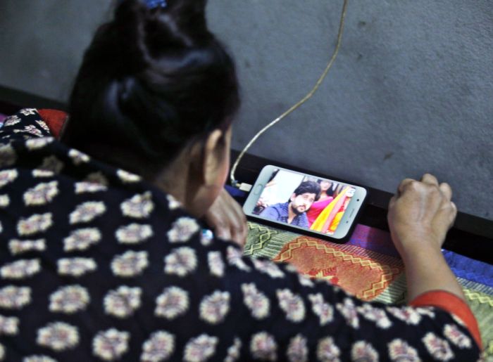 La imagen muestra a una mujer viendo un video de YouTube en su celular.