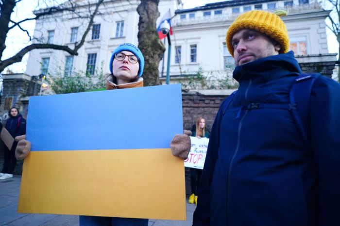 Un hombre y una mujer protestan con la bandera de Ucrania.