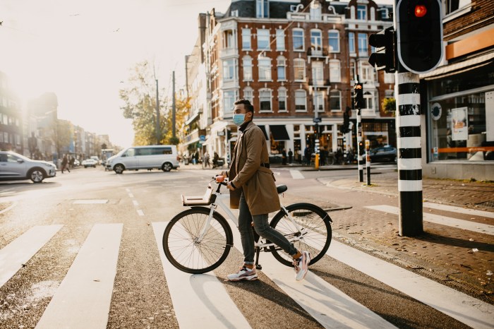 Un hombre en bicicleta en medio de una calle desierta de los Países Bajos.