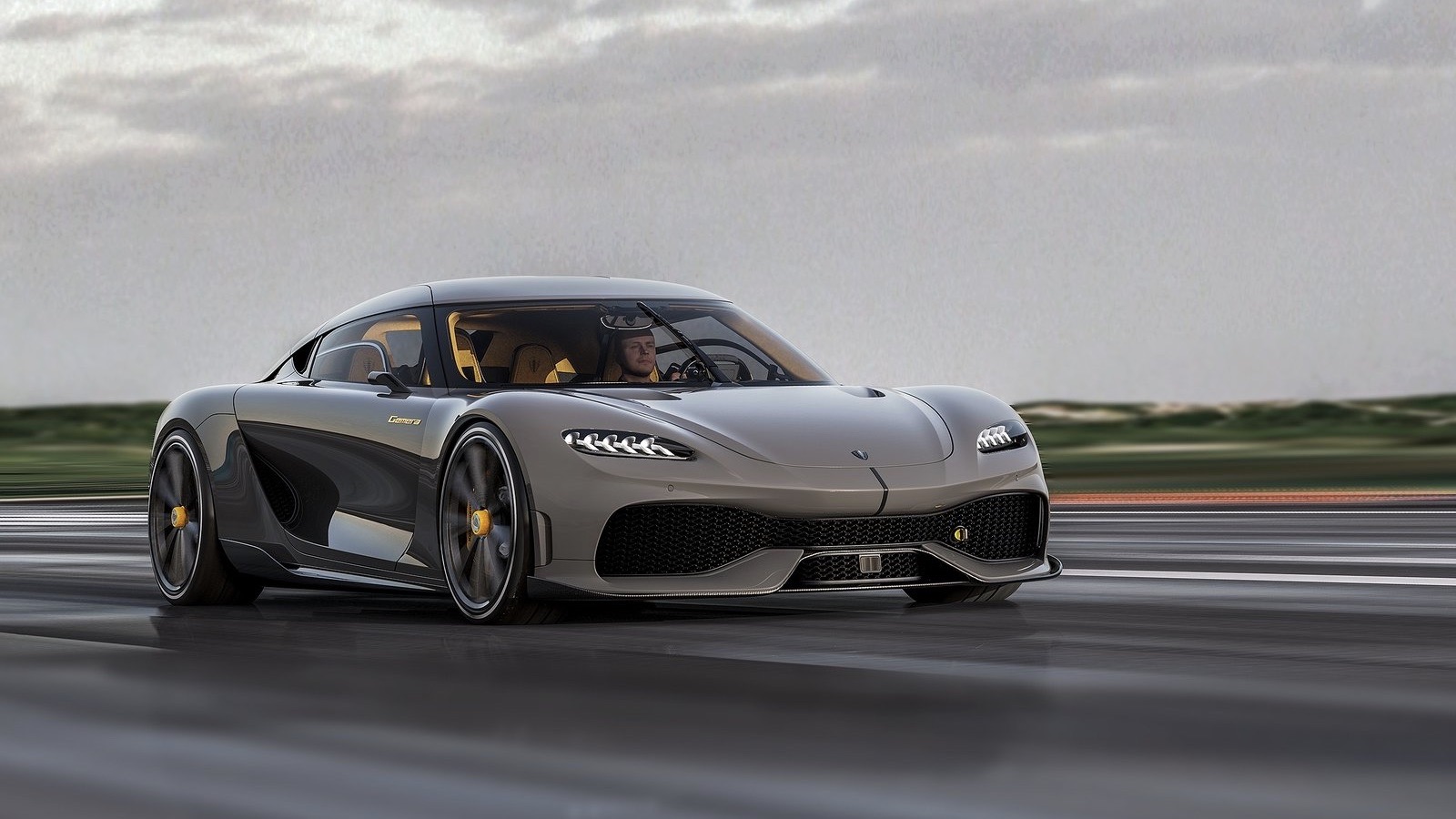 Vista frontal de dos cuartos del Koenigsegg Gemera gris, corriendo en una pista.