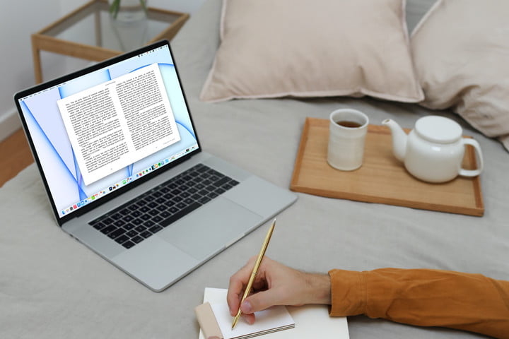 Una persona en la cama con la aplicación de Apple Books abierta en una MacBook.