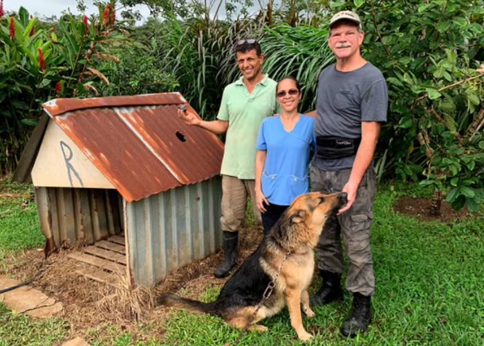Una familia posa al lado de una casa de perro que fue golpeada por un meteorito.