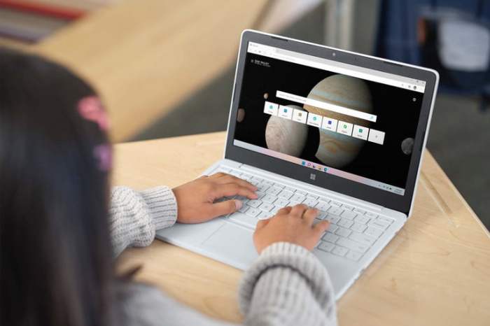 Una niña trabajando con una Chromebook en color blanco sobre una mesita.