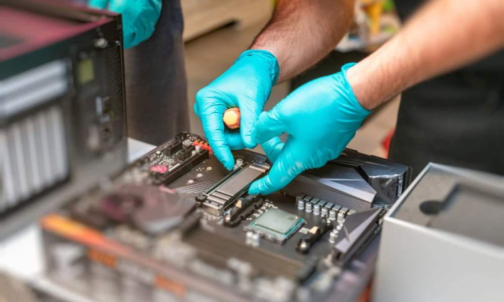 Una persona instalando una unidad SSD en una computadora.