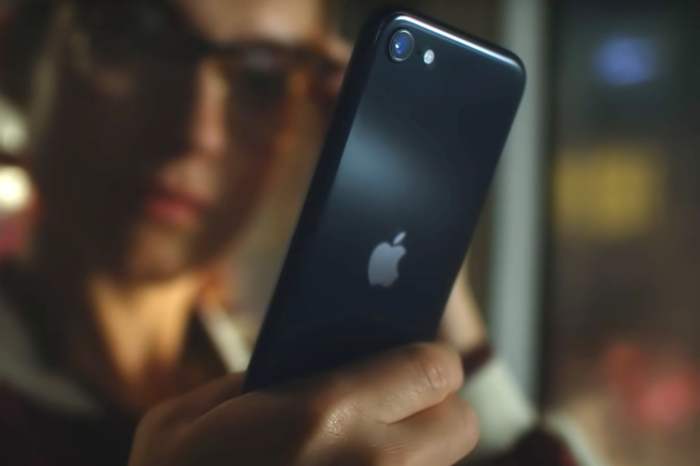 iPhone SE (2022) color negro en la mano de una persona tomandose una selfie.