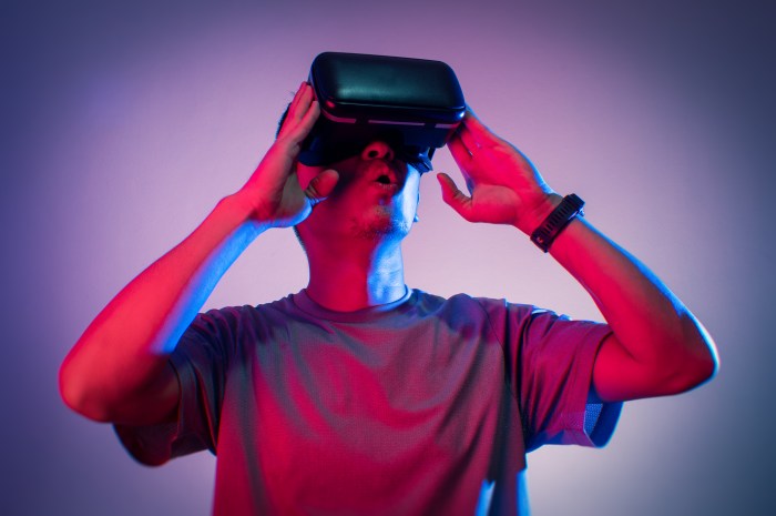 Un hombre joven reacciona con sorpresa mientras usa unos lentes de realidad virtual.