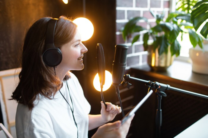 Mujer frente a un micrófono en lo que parece ser una grabación de un podcast.