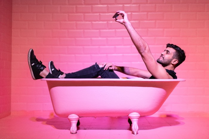 Un hombre se toma una fotografía acostado en una bañera