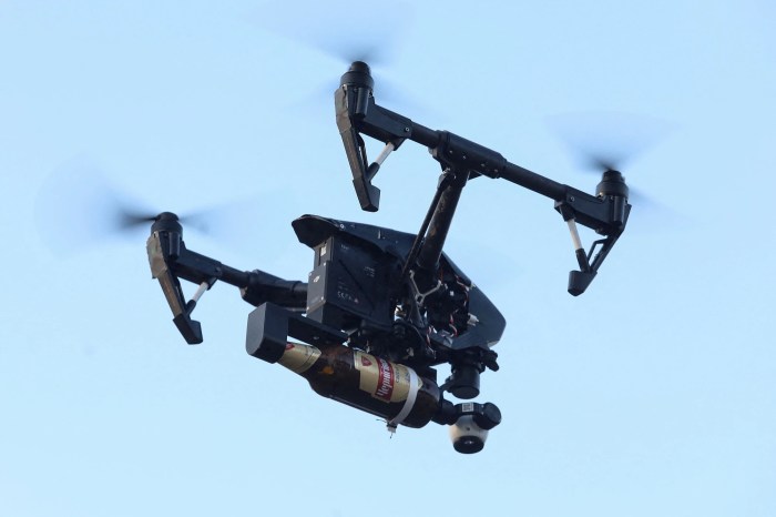 un dron vuela con una bomba molotov adosado en sus brazos