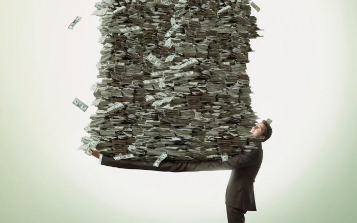 Un hombre sosteniendo una montaña de dinero.
