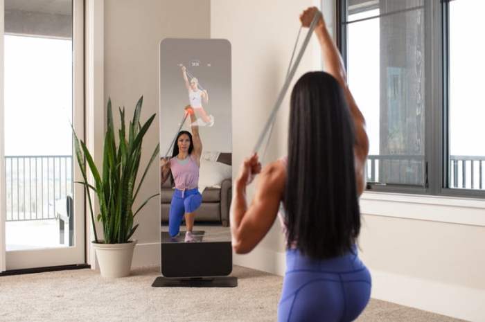 Una chica se ejercita frente al espejo de ejercicios ProForm Vue.