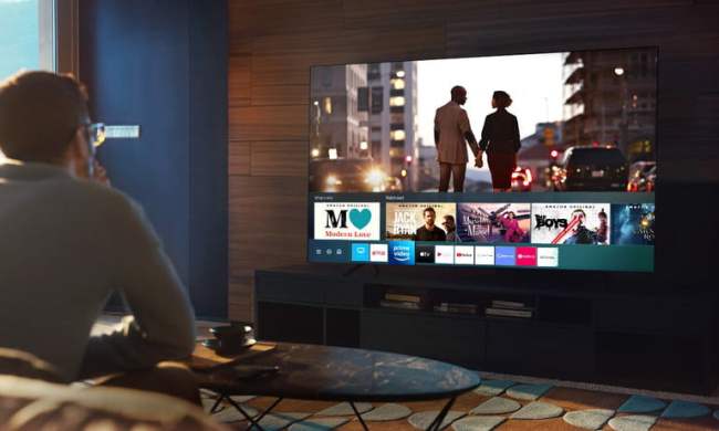 Hombre viendo un televisor Samsung 2020 en la sala de su hogar.