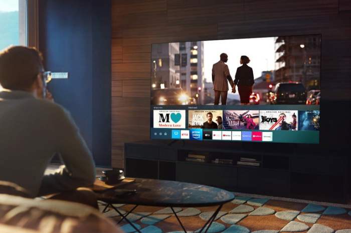 Hombre viendo un televisor Samsung 2020 en la sala de su hogar.