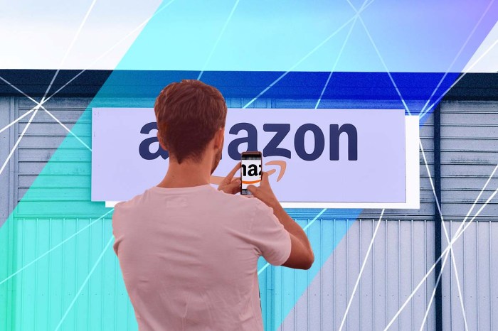Una persona con su celular apuntando hacia el logo de Amazon.