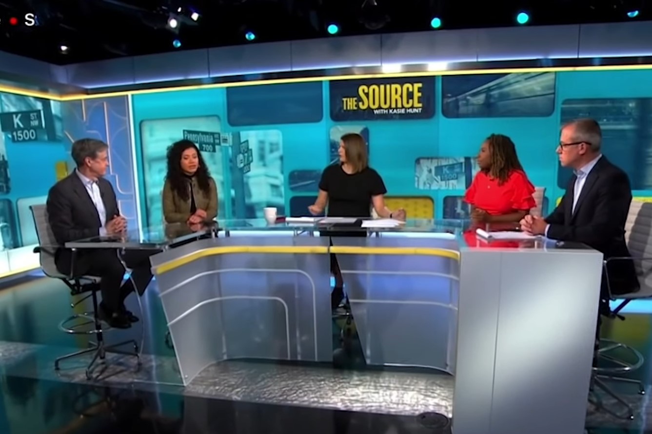 Un hombre camina frente al logo gigante de CNN