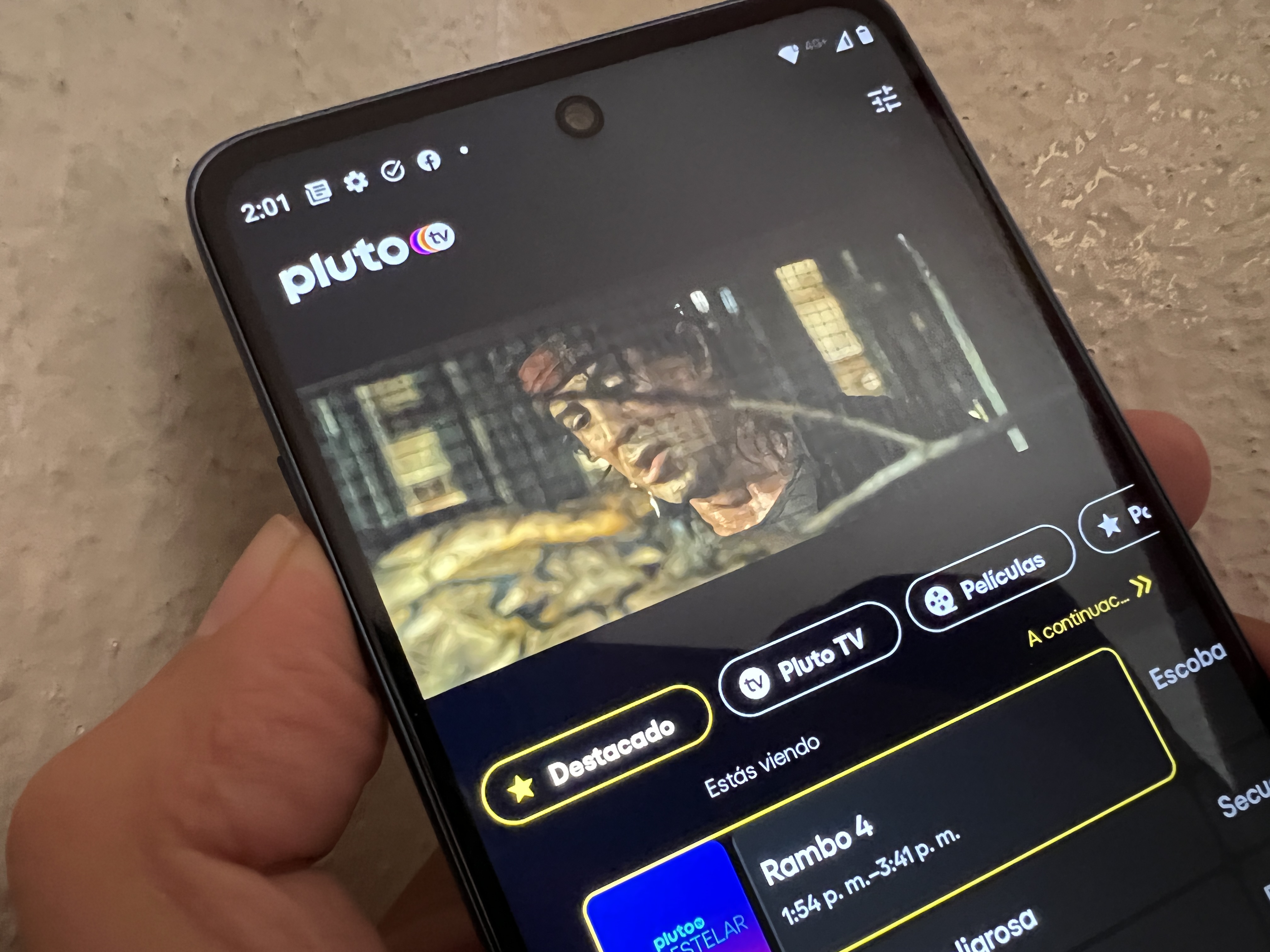 Teléfono está desplegando la interfaz principal de Pluto TV, servicio de streaming de video.