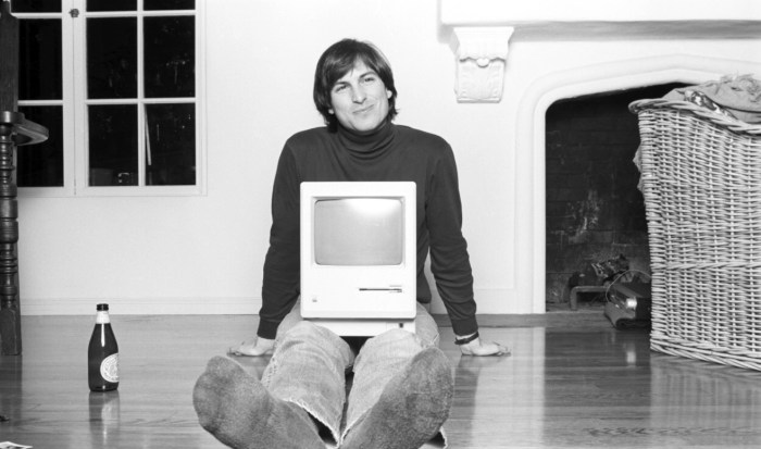 Steve Jobs con un computador Machintosh sobre sus rodillas en"Steve Jobs: The Man in the Machine" (2015).