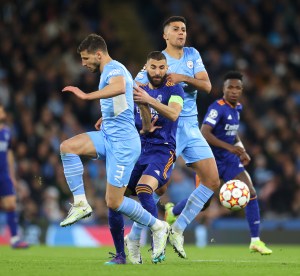 Dónde y cómo ver la Champions League – Karim Benzema entre dos jugadores del Manchester City.