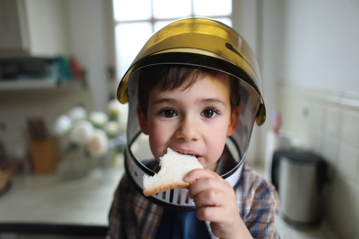 por que astronautas no pueden comer pan espacio a four year old boy wearing cosmonaut helmet  eating sliced bread in the kitc
