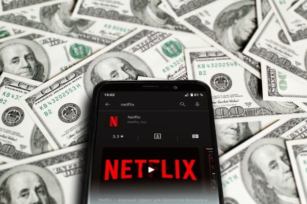 Celular con app. de Netflix sobre billetes de 100 dólares – ¿Cuánto cuesta Netflix? Te explicamos todos sus planes y sus precios.