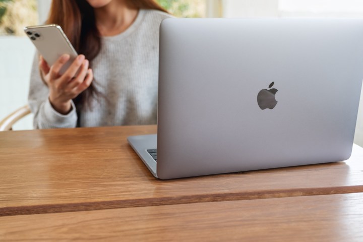Mujer con un iPhone y una MacBook de Apple.