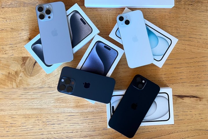 iPhone 15 Pro Max, iPhone 15 Pro, iPhone 15 Plus y iPhone 15 sobre sus cajas y en una mesa.