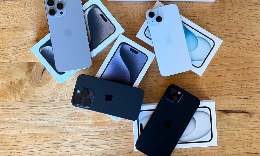 iPhone 15 Pro Max, iPhone 15 Pro, iPhone 15 Plus y iPhone 15 sobre sus cajas y en una mesa.