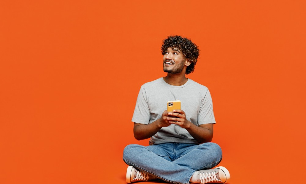 Hombre feliz con su teléfono celular – Cómo desbloquear un celular para cambiar de compañía en EE.UU.