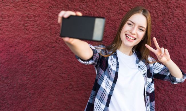 apps para mejorar fotos borrosas ia android mujer alegre que toma selfie signo paz contexto texturizado pared aspera