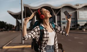 mejores audifonos viajar encantadora chica rubia gafas sol auriculares rojos escucha musica  1