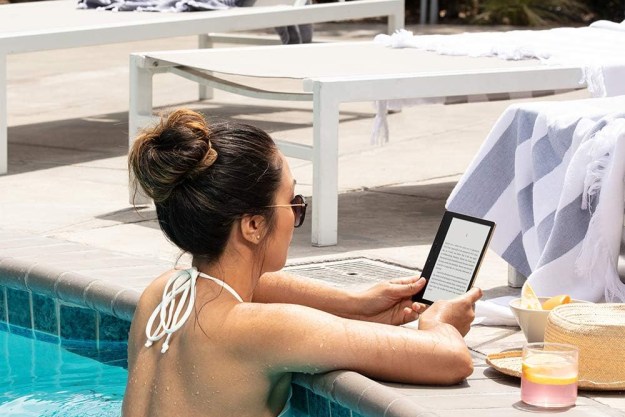 Mujer lee en Kindle en una piscina