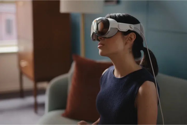 Una mujer inclina la cabeza mientras lleva puesto el Apple Vision Pro.