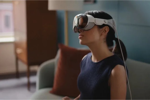 Una mujer inclina la cabeza mientras lleva puesto el Apple Vision Pro.