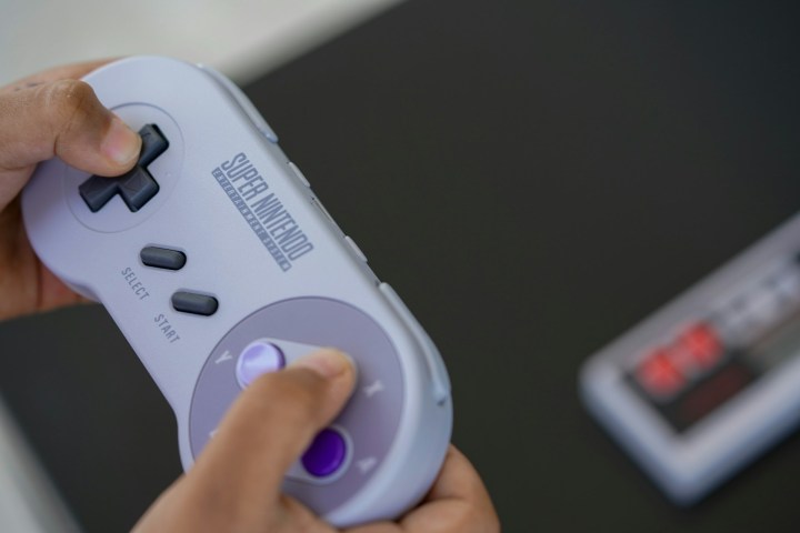 Unas manos sosteniendo un control de Super Nintendo (SNES).