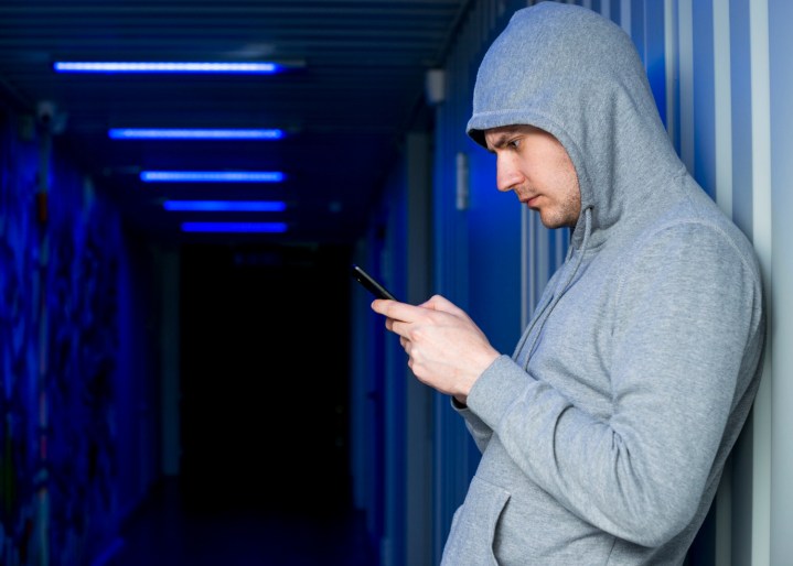 A man uses a mobile phone in the dark.