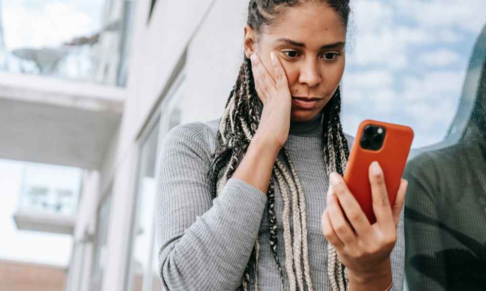 Una mujer preocupada mirando su celular.